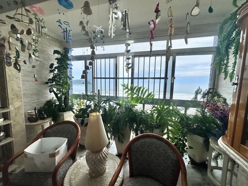 Sala bem iluminada com vista para o mar.