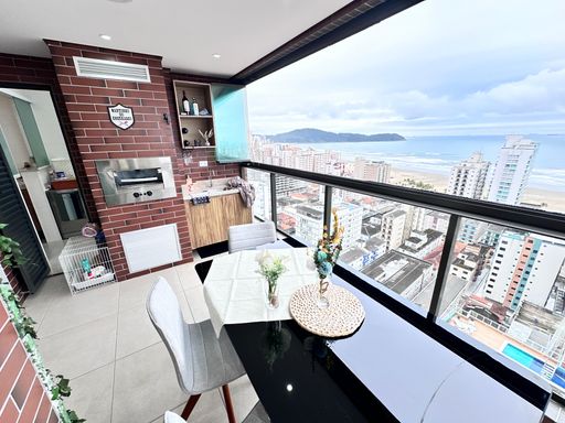 Sacada gourmet envidraçada com vista para o mar.