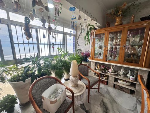 Sala bem iluminada com vista para o mar.