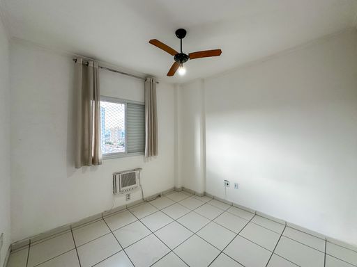 Suíte com ar-condicionado de janela e ventilador de teto.