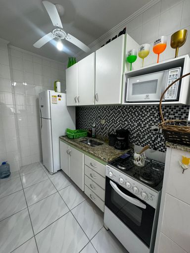 Cozinha com armários planejados, fogão e geladeira.