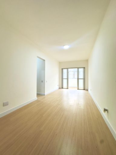 Sala ampla bem iluminada de dois ambientes com uma sacada.