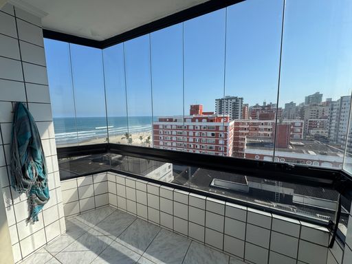 Sacada envidraçada com vista para o mar.