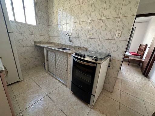 Cozinha com uma, pia, gabinete embutido, fogão e armários.