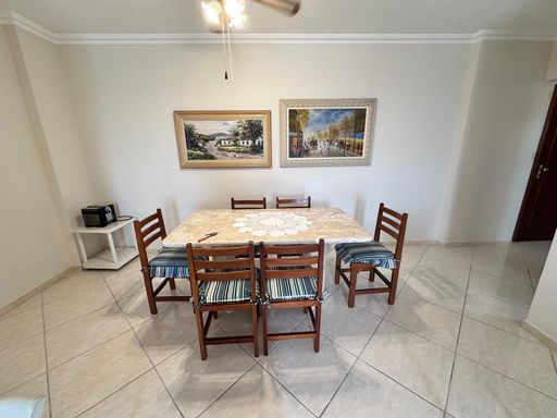 Sala de jantar com mesa em granito para 6 lugares  e  ventilador de teto.