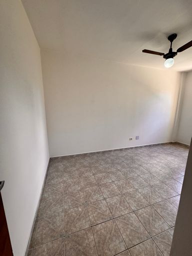 Dormitório espaçoso e bem iluminado com um ventilador de teto.