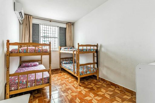 Dormitório bem iluminado, com dois beliches e ar-condicionado.