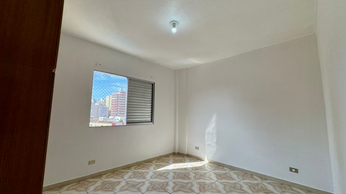 Dormitório bem iluminado com um guarda-roupa.