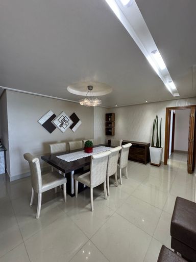 Sala ampla de 2 ambientes com sofá, mesa de jantar e ar-condicionado.