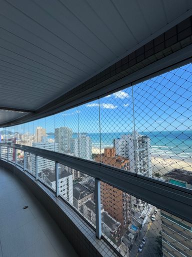 Sacada gourmet envidraçada com vista para o mar.