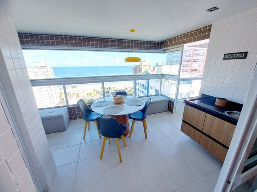 Sacada envidraçada com mesa para 04 pessoas com vista para o mar.