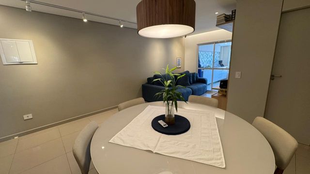 Sala ampla de 2 ambientes com um sofá, mesa de jantar e ar-condicionado.