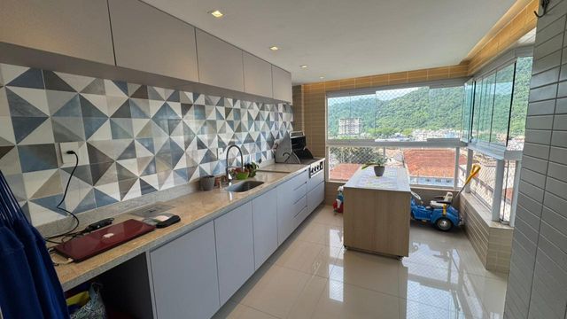 Sacada gourmet envidraçada com vista para a montanha.