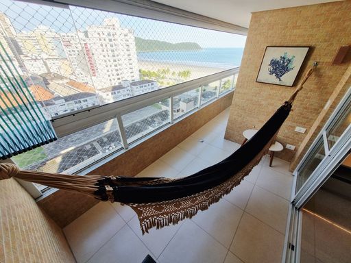 Sacada envidraçada com vista para o mar com dois pontos para churrasqueira a gás.