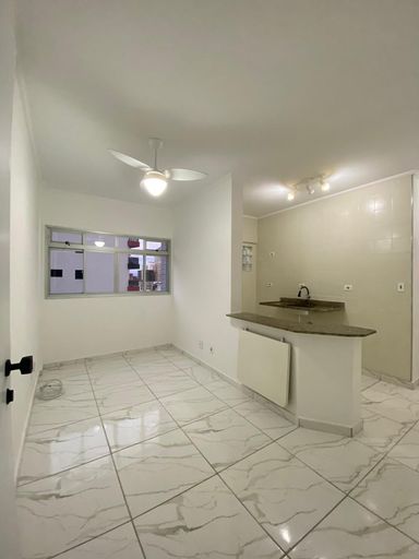 Sala com piso reformado com ventilador de teto e uma janela grande.
