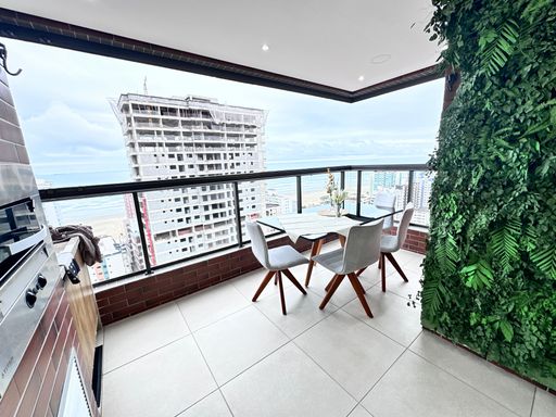 Sacada gourmet envidraçada com vista para o mar.