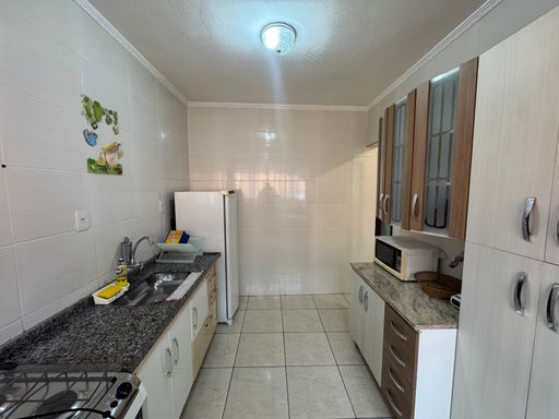Cozinha prática, com pia, gabinete e armários.