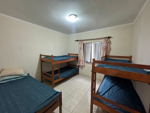 Dormitório com dois beliches e uma cama de casal.