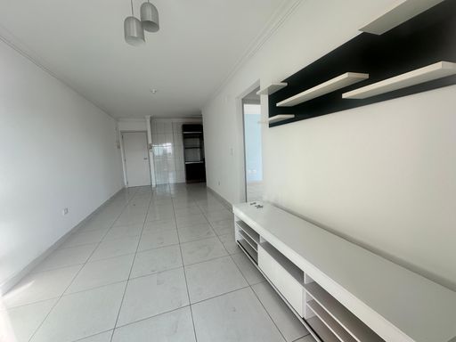 Sala de 2 ambientes com painel de TV e paredes brancas.