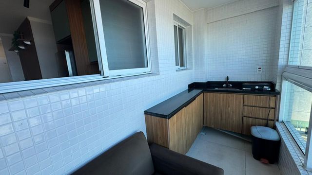 Sacada gourmet envidraçada com vista para o mar.
