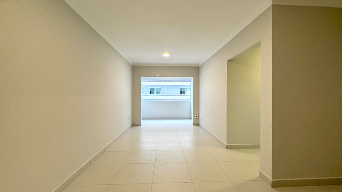Sala de dois ambientes bem iluminado.
