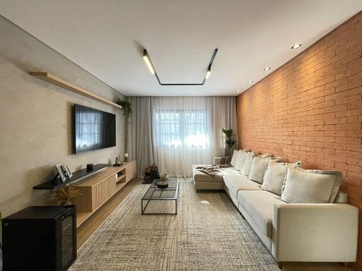 Sala espaçosa, muito bem iluminada, com sofá e piso laminado.