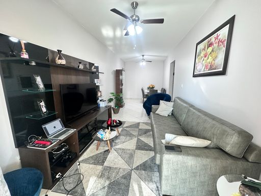 Sala de 2 ambientes com mesa de jantar, sofá, ventilador de teto e acesso a sacada gourmet.