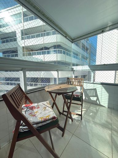 Sacada gourmet envidraçada com churrasqueira a carvão e vista livre.