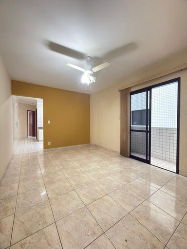 Sala espaçosa com um ventilador de teto e sacada.