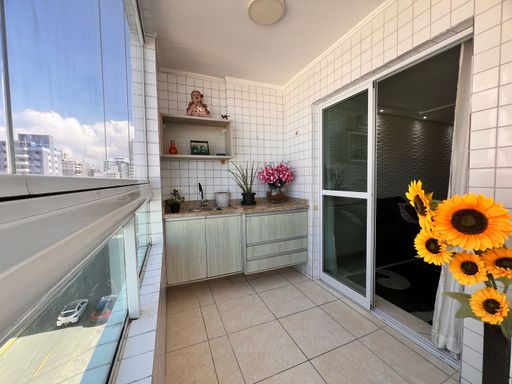 Sacada envidraçada com vista para o mar.