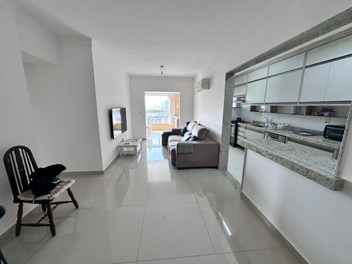 Sala de 2 ambientes com muita iluminação natural e sofá e ar-condicionado.