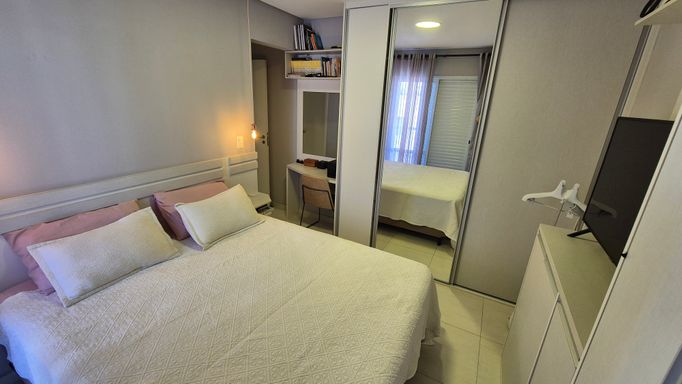 Suíte com armários planejados com uma sacada privativa.