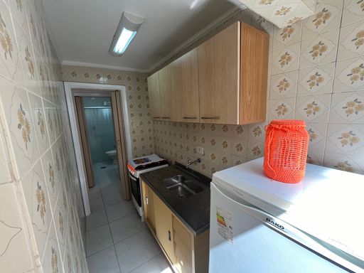 Cozinha com uma pia, fogão e geladeira.