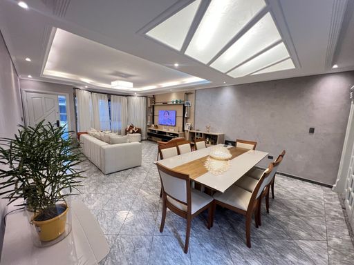 Sala ampla de 2 ambientes com teto rebaixado em gesso com iluminação em LED.