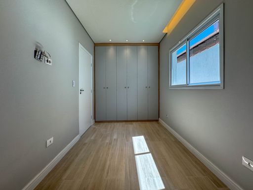 Dormitório com teto rebaixado em gesso com iluminação em LED e armários planejados.