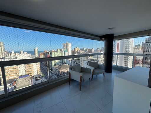 Sacada gourmet envidraçada com vista para o mar.
