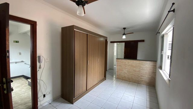 Sala living com uma guarda-roupa e dois ventilador de teto.