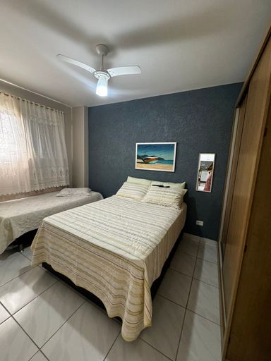 Dormitório com 1 cama de casal, 1 cama de solteiro, 1 guarda roupa e ventilador de teto.