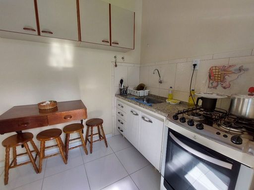 Cozinha com um fogão, pia e gabinete.