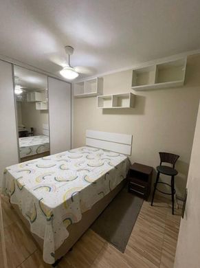 Dormitório espaçoso com guarda-roupa planejada e ventilador de teto.