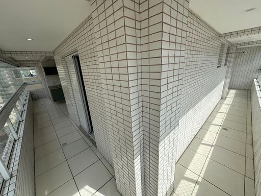 Sacada em L, envidraçada, com vista para o mar.