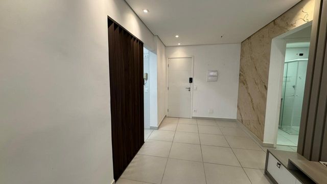 Sala de 2 ambientes com parede de mármore.