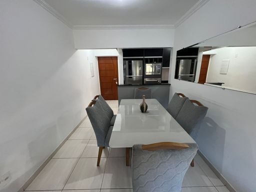 Sala de 2 ambientes com uma mesa de jantar, sofá e ar-condicionado.