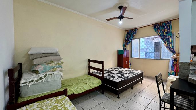 Sala living ampla, mobiliada e com ventilador de teto.