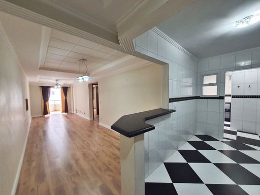 Sala ampla e bem iluminada e cozinha americana.