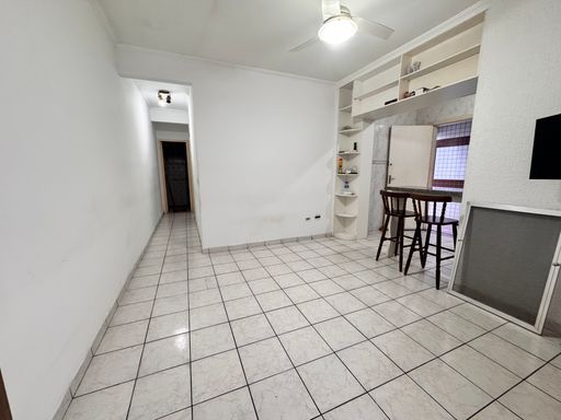 Sala ampla com paredes brancas e ventilador de teto.