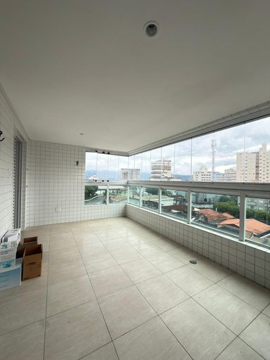 Sacada gourmet envidraçada com vista para o mar.