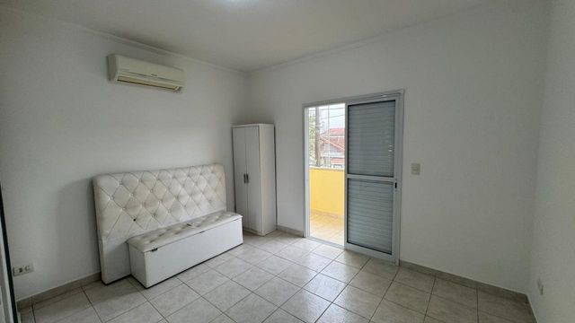 Suíte com ar-condicionado e sacada envidraçada privativa de frente para rua.