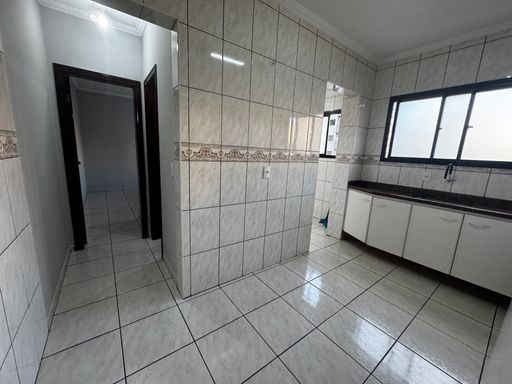 Cozinha com uma pia, gabinete, geladeira branca e fogão.