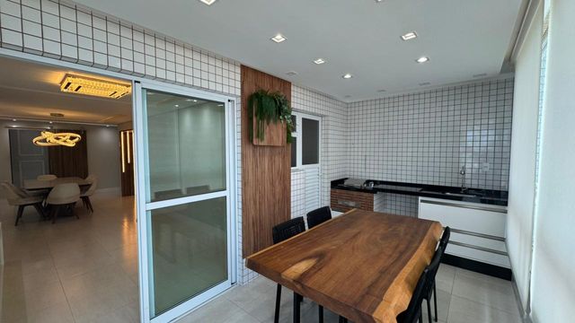 Sacada gourmet envidraçada com vista para o mar.